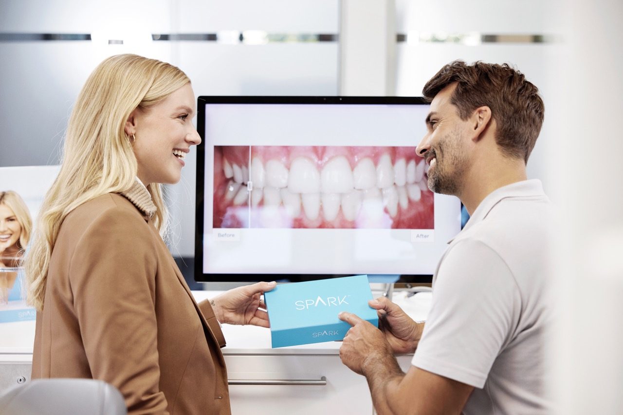Reviewing a before-and-after digital treatment preview with a Spark™ aligner box visible